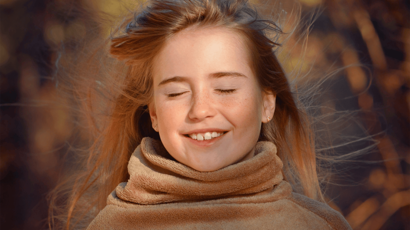 Chica a la que le da el viento en la cara y le mueve el pelo