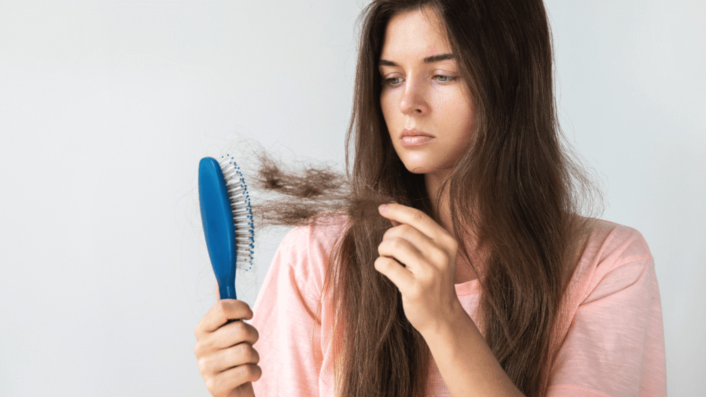 mujer mirando el peine porque se le cae el cabello debido al cambio de estacion